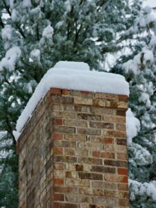 A code inspector examines roof flashing and attic ventilation on a snow-ready residential roof.